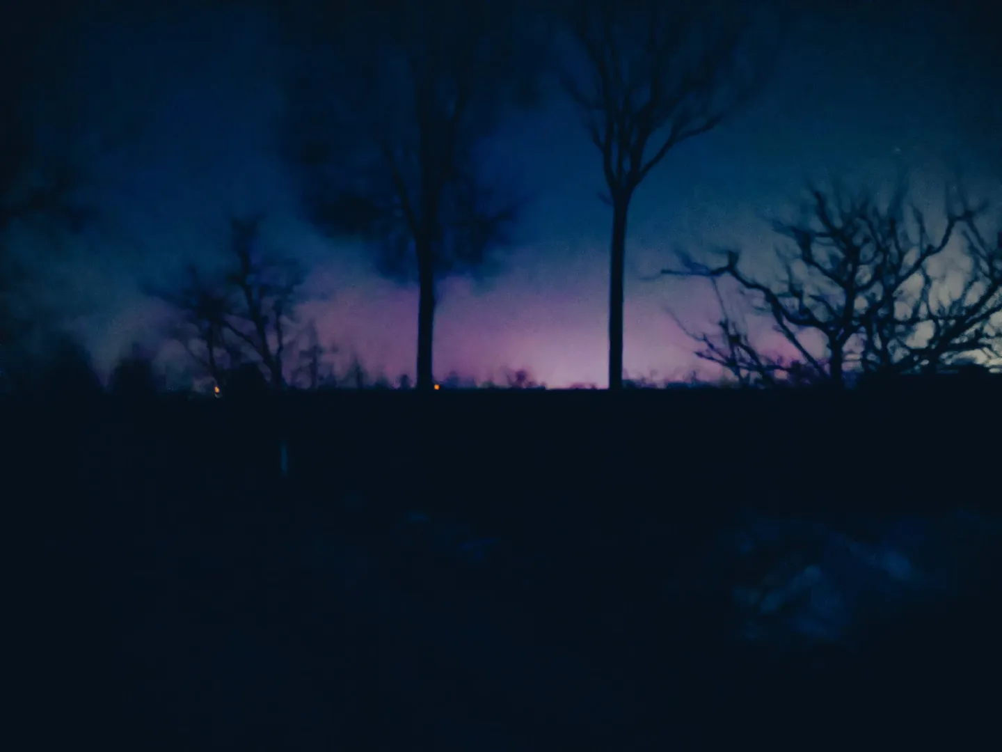 夜晚一片漆黑,天边有远处的灯亮